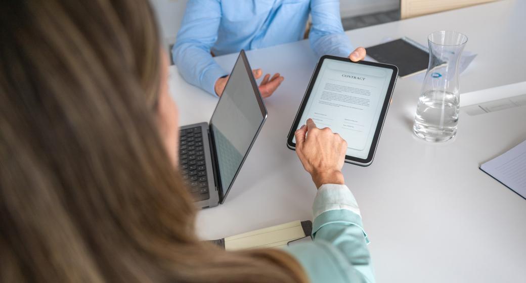 Illustration d'une femme signant un document numérique lors d'une réunion